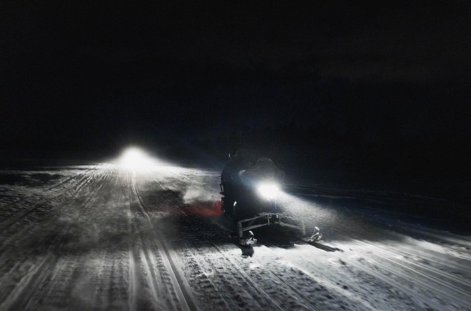 Northern lights safari by snowmobile - Campfire warmth and the BBQ moment in the winter dark